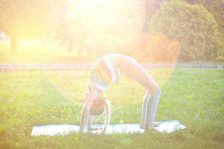 Healthy lifestyle - little girl doing yoga in the park. Healthy and Yoga Concept