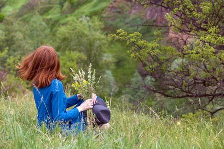 summer - beautiful girl on a meadow with a bouquet of wildflowersの写真素材