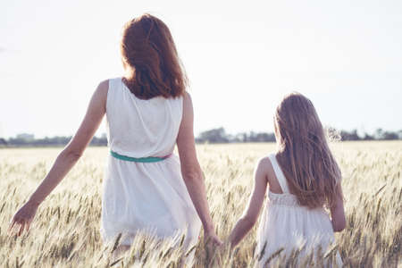 happy summer and vacation. Family - mother with her daughter in a wheat fieldの写真素材