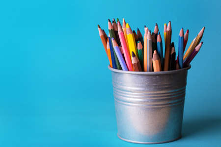 bucket with colorful pencils on a blue backgroundの写真素材