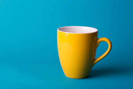 beautiful coffee yellow cup on blue backgroundの写真素材