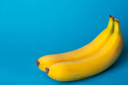 delicious ripe bananas on a blue backgroundの写真素材