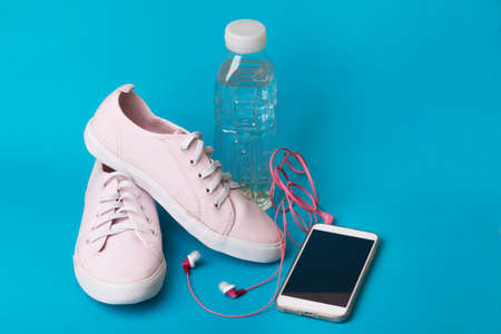 concept of running and healthy lifestyle. what to take for a run - sneakers, water, smartphone and headphonesの写真素材