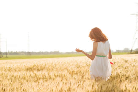 happy summer and freedom. Beautiful girl at the wheat field on a sunny dayの写真素材