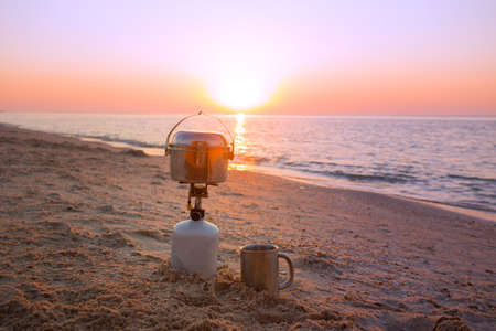 happy trip - view of the sea,  burner, bowler, cup on the beach at dawn. Ukrainian landscape at the Sea of Azov, Ukraineの写真素材