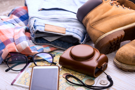 background for a trip - map, glasses, camera, smartphone, shoes, bag, jeans, shirt, coins