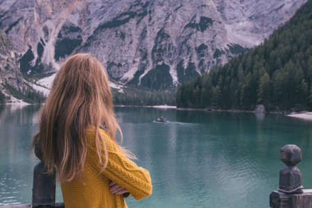 autumn - girl and view of well-known tyrolean lake lago di Braies Dolomites Italyの写真素材