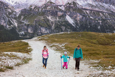 happy family - smiling mother and two sisters girls hikers at the mountains Dolomites, Italy. Cinque Torriの写真素材