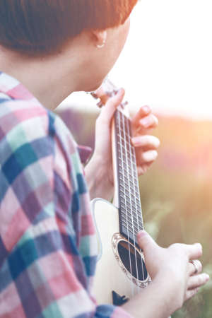 girl playing on ukulele. hands playing a guitar close-upの写真素材