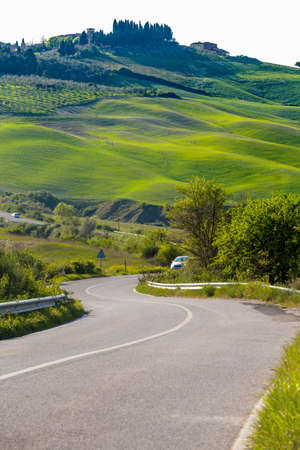 empty road and green hill before the rain in Tuscany, Italyの写真素材