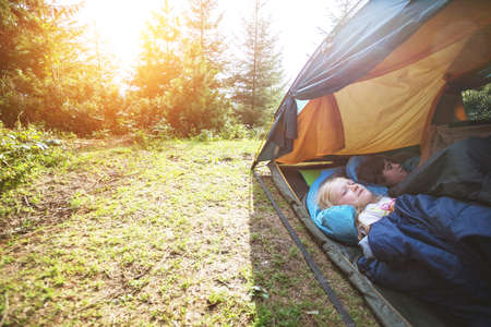 hike and camping life. hiking in the mountains with children - smiling children in a tentの写真素材