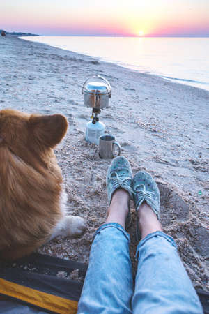 happy weekend by the sea - girl with a dog in a tent on the beach at dawn.の写真素材