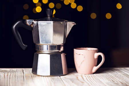 the girl pours coffee from a geyser coffee maker into a cup and bokeh in the backgroundの写真素材
