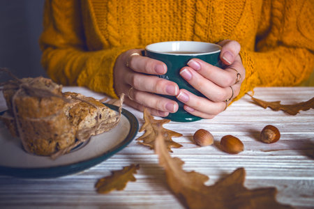 Beautiful autumn background - girl is holding a cup of tea in hands