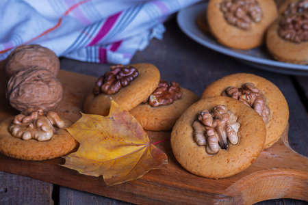 gingerbread cookies with walnuts on a table and a cup of milkの写真素材