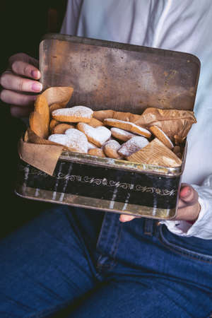 homemade cakes for Valentine's Day - girl holding a retro box with gingerbread cookies in the shape of a heartの写真素材
