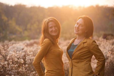 happy smiling girlfriend outdoors at sunsetの写真素材