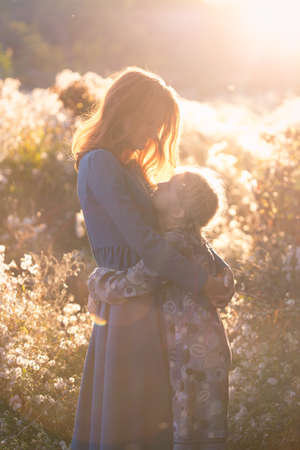 happy family.  smiling mom and daughter in the autumn park.の写真素材
