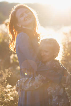 happy family.  smiling mom and daughter in the autumn park.の写真素材