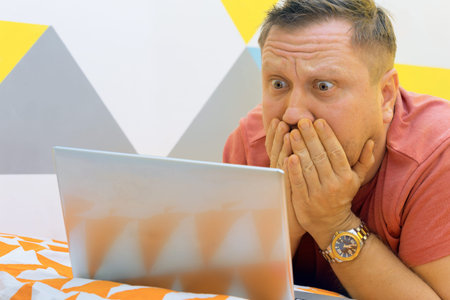man on the bed working on a laptop. human emotions