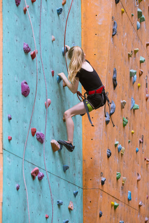 bouldering, little girl climbing up the wall
