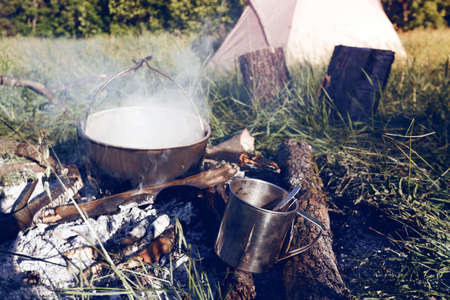 kettle suspended over camp fire. hiking in the mountainsの写真素材
