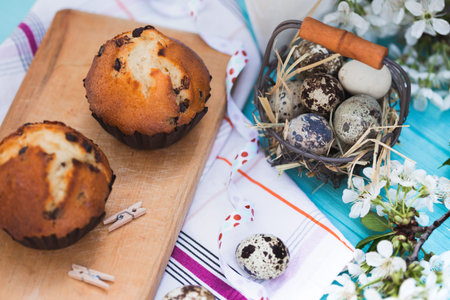 happy easter - basket of eggs  and cupcakes on the background of cherry blossoms