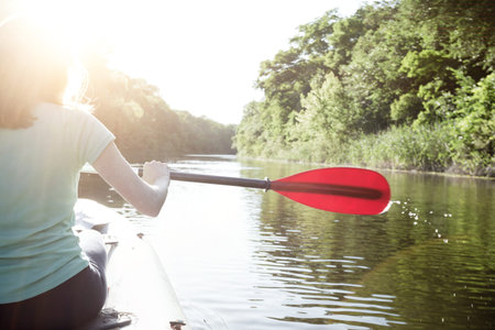 summer and active sport. a girl kayaking in sunset time