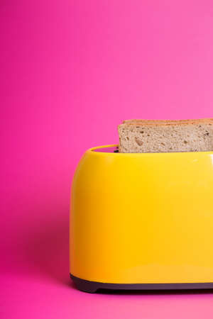 bright, fun breakfast. yellow toaster on a pink backgroundの写真素材