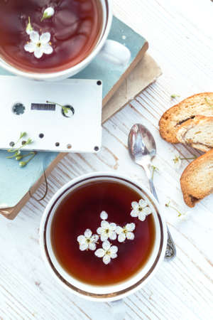 still life - cups of tea, crackers, books and tapes on a wooden background. atmosphere and moodの写真素材