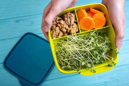 healthy snacks for schoolchildren and students. study and healthy eating.girl holding lunch box with...