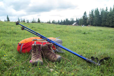 travel. the tourist goes on a hike through the mountains - a backpack, boots and Trekking polesの写真素材