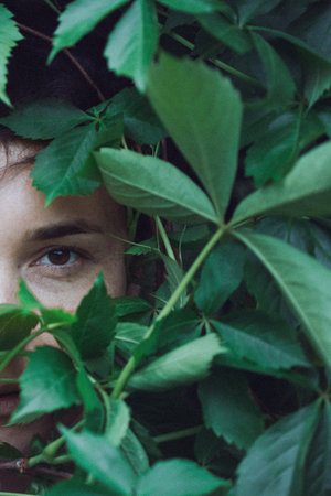 portrait of a girl in the leaves of wild grapes. natural background