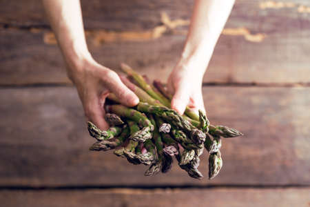 girl holding asparagus in her hands. veganism and raw foodsの写真素材