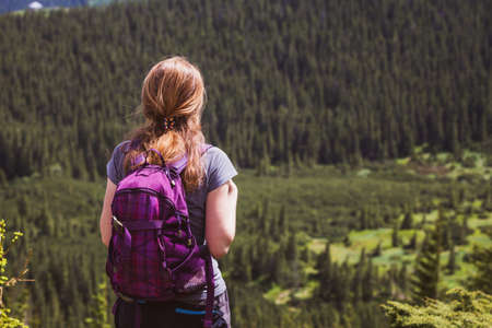 girl hiker with a backpack standing on the background of mountains and forests. Vorokhta - Ukrainian landscape.
の写真素材