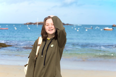 pretty girl walking on the shore of the sea at  the Tregastel, normandy. France