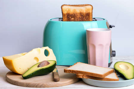 bright, fun breakfast. cyan color toaster on a wooden backgroundの写真素材