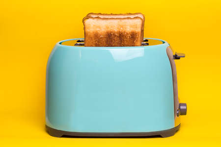 bright, fun breakfast. cyan color toaster on a yellow backgroundの写真素材