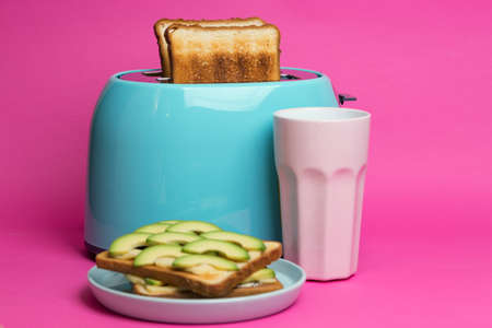 bright, fun breakfast. cyan color toaster on a pink backgroundの写真素材