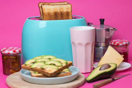 bright, fun breakfast. cyan color toaster on a pink background