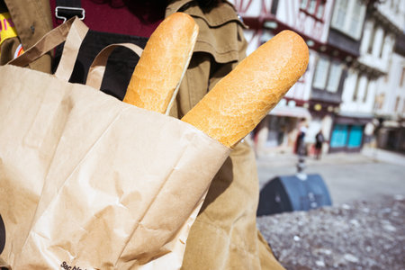 French girl with baguettes on the street side of the city. Morlaix, France. gastronomic tourism