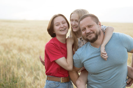 happy family outdoor. dad with daughters at the field