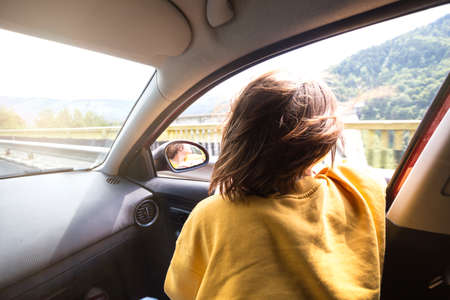 Summer Road Trip. Happy beautiful girl traveling in a car across  at the mountains. Romaniaの写真素材