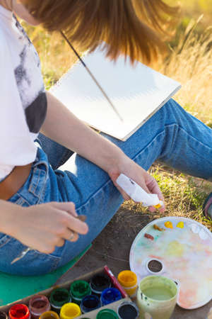 time of creativity. Painting En Plein Air. girl draws a landscape in natureの写真素材