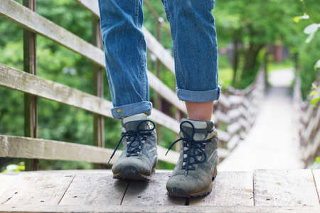 hiking boots closeup. tourist standing on a suspended wooden bridge. Norwayの写真素材