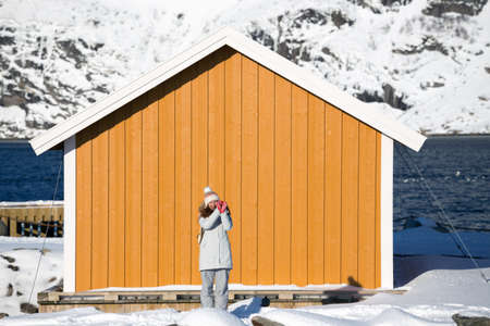 happy smiling tourist girl near rorbu. Lofoten islands. Norwayの写真素材