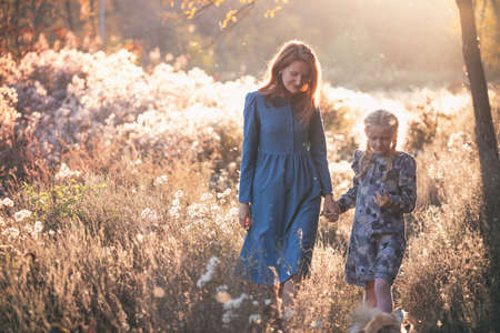 happy family.  smiling mom and daughter in the autumn park.の写真素材