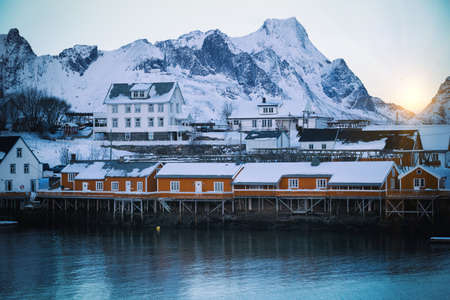 traditional norwegian wooden house rorbu to stand on the shore of the fjord and mountains in the distance. Lofoten Islands. Norway. world travelの写真素材