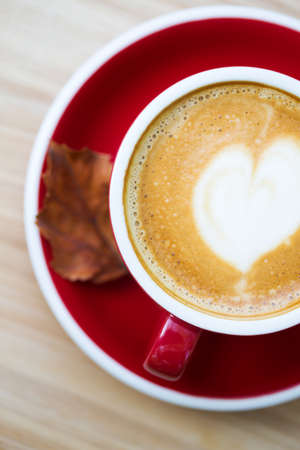 red cup of coffee against the backdrop of autumn foliage. fall and relaxの写真素材