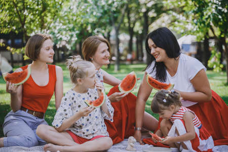 Summer -  big happy family at a picnic with watermelon.  Fun juicy summer and bright family picnicの写真素材